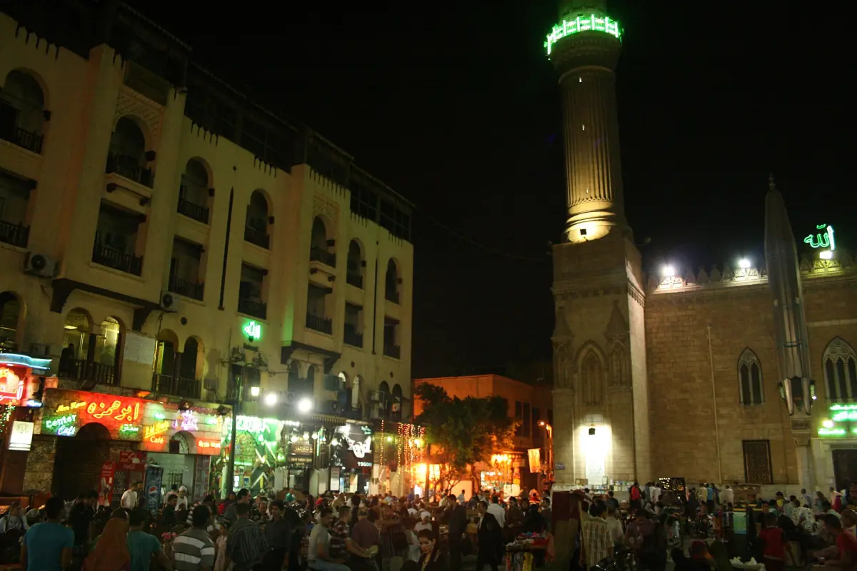 Beleuchtetes Minarett und Marktplatz am Abend