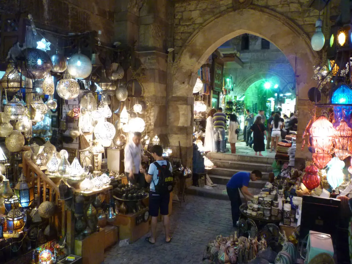 Gewölbte Gasse im Khan el-Khalili voller leuchtender Lampen und Metallwaren