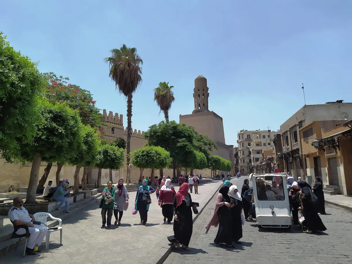 Muizz-Straße in Kairo mit Palmen und historischen Mauern